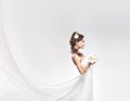 Young attractive bride with the bouquet of white roses