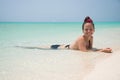 Brunette in bikini lying on sandy beach of Zanzibar island