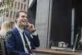 Young attractive brunette businessman talking by mobile phone and smiling. Royalty Free Stock Photo