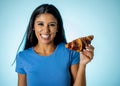 Young attractive brunette feeling joy and guilt at the thought of eating chocolate croissant Royalty Free Stock Photo