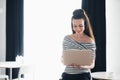 Young attractive brunette woman holding a laptop and typing, while looking at the screen. Adult female surfing the Royalty Free Stock Photo
