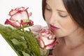 Young attractive brunette woman smells at roses Royalty Free Stock Photo