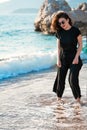 Young attractive woman walking on a sunny beach at shore. Traveler and blogger Royalty Free Stock Photo