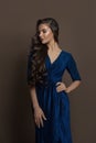 Young attractive brunette woman wearing blue evening gown on brown background Royalty Free Stock Photo