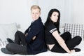 Young attractive business couple in love - sitting on bed back to back Royalty Free Stock Photo