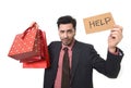 Young attractive business man in stress holding lot of shopping bags and help sign looking tired bored and worried