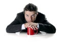 Young attractive business man in suit sitting with red mug or cup of coffee