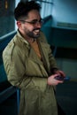 Young attractive business man in winter coat using smartphone in the underpass in city. Royalty Free Stock Photo