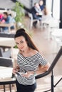 Young attractive business woman with long straight hair holds a notebook or job interview in a coffee-shop or cafe Royalty Free Stock Photo