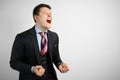 Young attractive businessman businessman in suit on gray background in rage, anger and madness Royalty Free Stock Photo