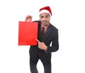 Young attractive businessman in Christmas Santa hat holding and pointing red shopping bag in December and New year sale Royalty Free Stock Photo