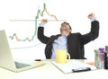 Businessman crazy happy after winning forex or stocks trade at office computer desk celebrating