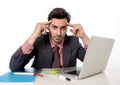 Young attractive businessman sitting at office desk working on computer laptop suffering headache Royalty Free Stock Photo