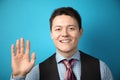 Young attractive businessman businessman in suit on blue background showing five fingers. Welcome gesture Royalty Free Stock Photo