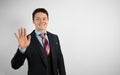 Young attractive businessman businessman in suit on gray background showing five fingers. Welcome gesture Royalty Free Stock Photo