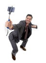 Young attractive businessman in suit and tie taking selfie photo with mobile phone camera and stick posing happy Royalty Free Stock Photo