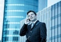 Young attractive businessman in suit and tie talking on mobile phone happy outdoors Royalty Free Stock Photo