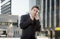 Young attractive businessman in suit and tie talking on mobile phone outdoors Royalty Free Stock Photo
