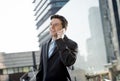 Young attractive businessman talking on mobile phone happy outdoors Royalty Free Stock Photo