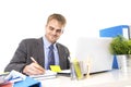 Young attractive businessman working busy with laptop computer at office desk smiling looking satisfied Royalty Free Stock Photo