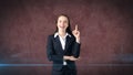 Young attractive businesswoman portrait in suit with standing and finger up, isolated studio background with copyspace. Royalty Free Stock Photo