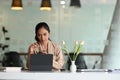 Young attractive businesswoman searching the data on internet with computer tablet.