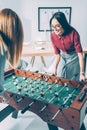young attractive businesswomen playing table football