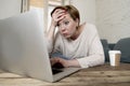 Young attractive and busy woman at home sofa couch doing some laptop computer work in stress looking worried in entrepreneur lifes Royalty Free Stock Photo