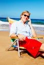 Young Attractive Casual Businessman Relaxing at the Beach Talking on Cell Phone Royalty Free Stock Photo