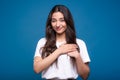 Young and attractive caucasian or arab brunette girl in a white t-shirt is grateful and holding her palms on her chest near the he