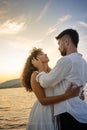 Young attractive caucasian bearded man with modern haircut holds his black Hispanic girlfriend`s head in his hands looking into