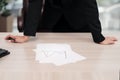 Young attractive Caucasian blond woman in black business suit sits at desk in bright office. Studying paper documents Royalty Free Stock Photo