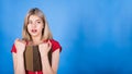 Young and attractive caucasian blonde girl is surprised, reading a book and looking at a copy space for advertising.