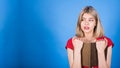 Young and attractive caucasian blonde girl is surprised, reading a book and looking at a copy space for advertising.