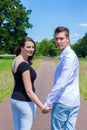 Young attractive caucasian couple hand in hand looking back Royalty Free Stock Photo