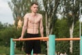 Young attractive Caucasian man doing push ups on the bars. Workout concept. Royalty Free Stock Photo