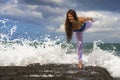 Young attractive and concentrated woman practicing acroyoga balance exercise and yoga flexibility and meditation on the sea at