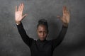 Young attractive and confident African American woman in hipster style raising up her arms and hands in stop sign demanding peace