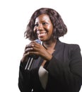 Confident black African American business woman with microphone speaking in auditorium at corporate event or seminar giving Royalty Free Stock Photo