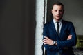 Young attractive and confident businessman in blue suit and black tie. Royalty Free Stock Photo