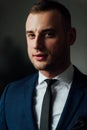 Young attractive and confident businessman in blue suit and black tie. Royalty Free Stock Photo