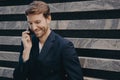 Young attractive confident businessman with neat beard in formal wear speaking on mobile outdoors Royalty Free Stock Photo