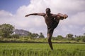 Young attractive contemporary ballet dancer and choreographer , a black afro American man dancing and posing on tropical rice Royalty Free Stock Photo