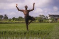 Young attractive contemporary ballet dancer and choreographer , a black afro American man dancing and posing on tropical rice Royalty Free Stock Photo