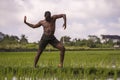 Young attractive contemporary ballet dancer and choreographer , a black afro American man dancing and posing on tropical rice Royalty Free Stock Photo