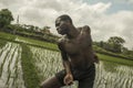 Young attractive contemporary ballet dancer and choreographer , a black afro American man dancing and posing on tropical rice Royalty Free Stock Photo