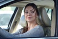 Young attractive coquettish caucasian woman in car flirting with pedestrian or other driver. Trendy and confident diverse woman be