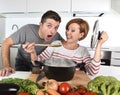 Young attractive couple at home kitchen with man tasting vegetable stew cooked by her wife smiling happy Royalty Free Stock Photo