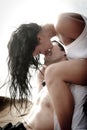 Young attractive couple kissing outdoors on beach rocks