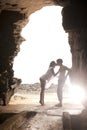 Young attractive couple kissing through rock archway Royalty Free Stock Photo